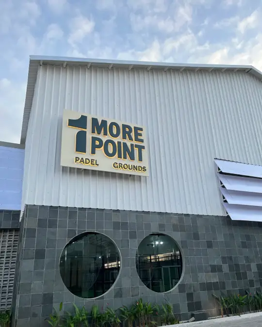 1More Point facade with round windows and the club sign