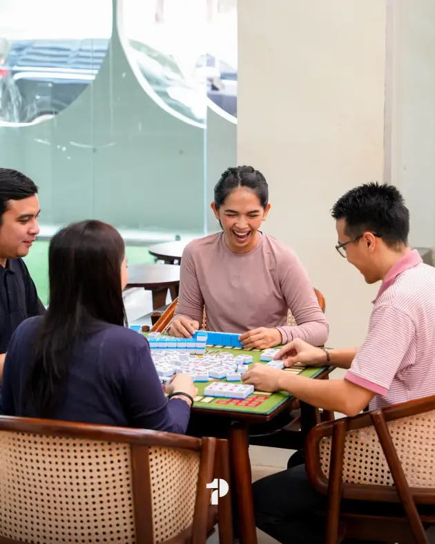 Friends laughing over a mahjong game